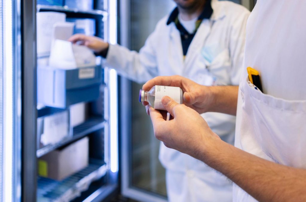 Doctor inspecting glass vial