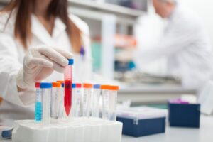 Laboratory researcher handling a temperature-sensitive biologic blood sample for clinical trial distribution