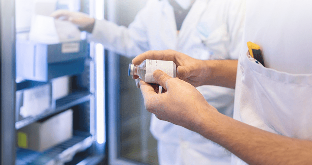 Pharmacy technician retrieving a temperature-sensitive medication from a refrigerator